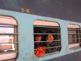 Zamřížovaná okénka vlaku a indické děti