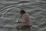Váranásí - žena se v řece nejen koupala, ale prováděla jakýsi obřad, při kterém nabírala a vylévala vodu, otáčel se, vodu pila a lila na sebe.