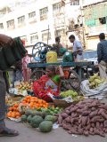 Váranásí - prodavačka zeleniny, za ní lis na cukrovou třtinu