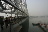 Kalkata - Howrah Bridge, obrovský most spojující dvě části města, přes něj se valí řady aut a zástupy lidí